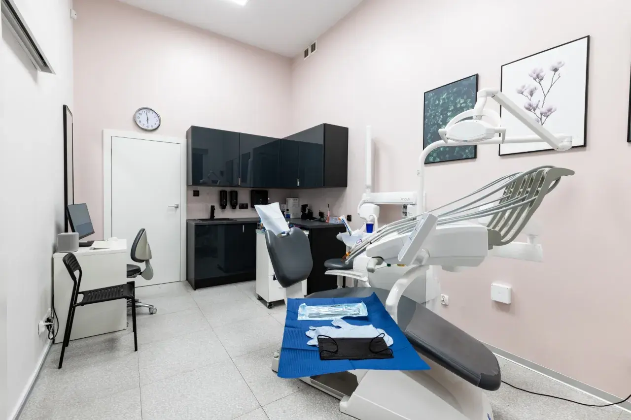 Nowoczesny gabinet stomatologiczny z fotelem dentystycznym i wyposażeniem.