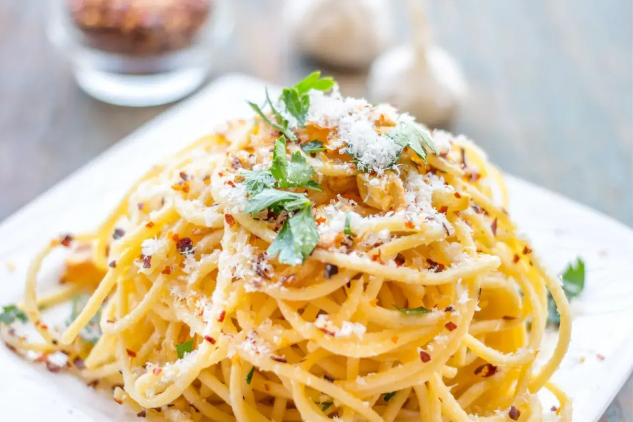 Pyszne spaghetti aglio olio, posypane parmezanem i natką pietruszki. Idealny przepis na szybki obiad.