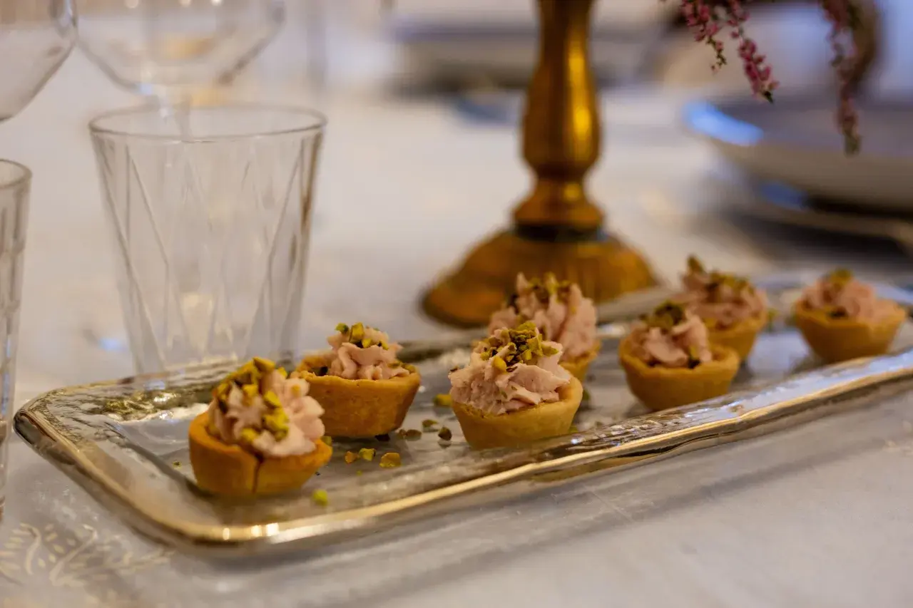 Tartellette rosa con pistacchi, pronte per un aperitivo a Verona.
