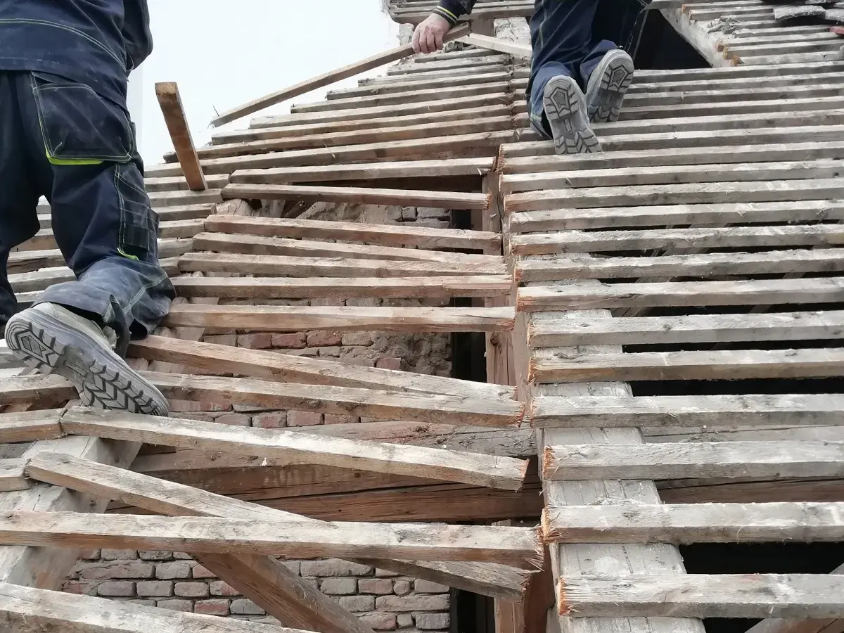 Pracownicy na dachu, wymiana krokwi. Czy wymiana krokwi wymaga pozwolenia na budowę?