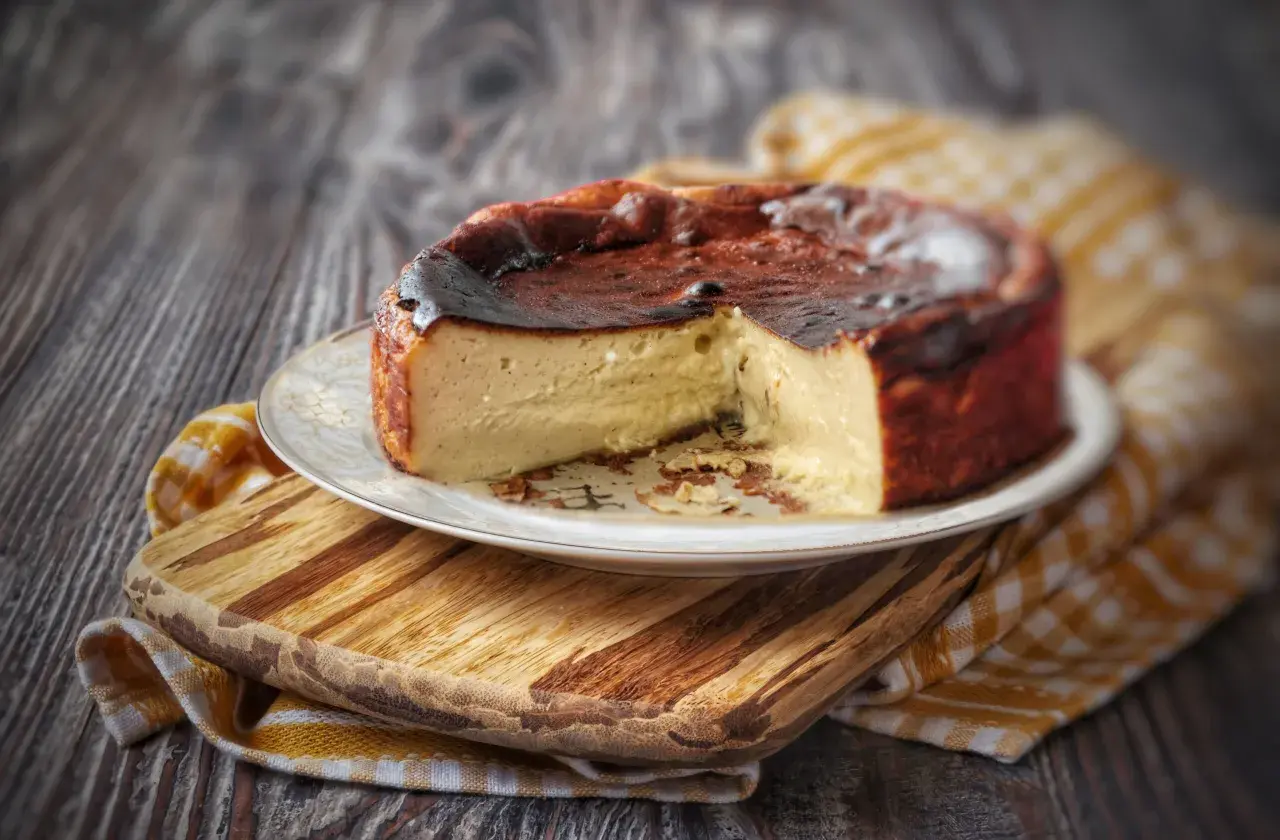 Una golosa cheesecake basca, con la sua crosta caramellata e l'interno cremoso, pronta per essere gustata.