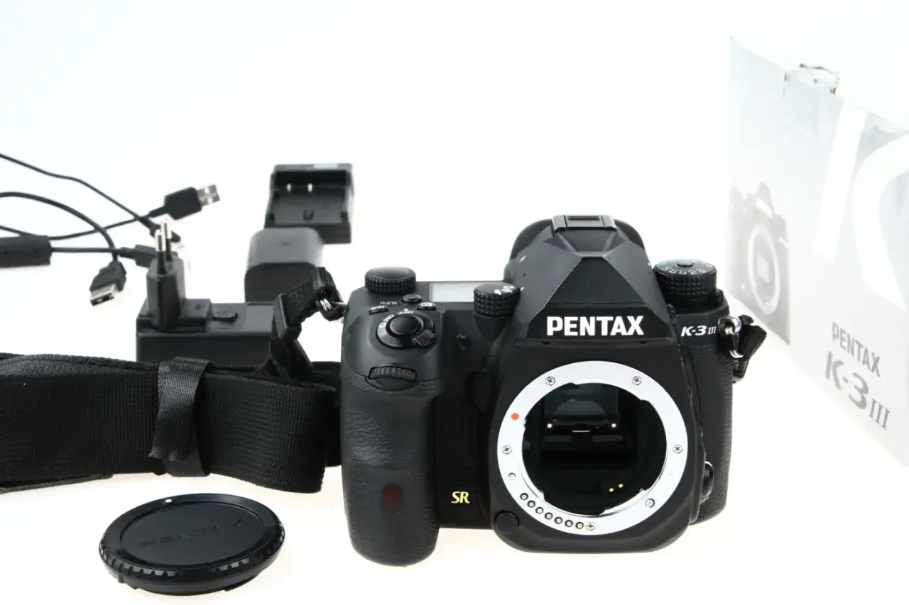 Czarny aparat Pentax K-3 III, ładowarka i akcesoria. Czy to lustrzanka czy bezlusterkowiec?