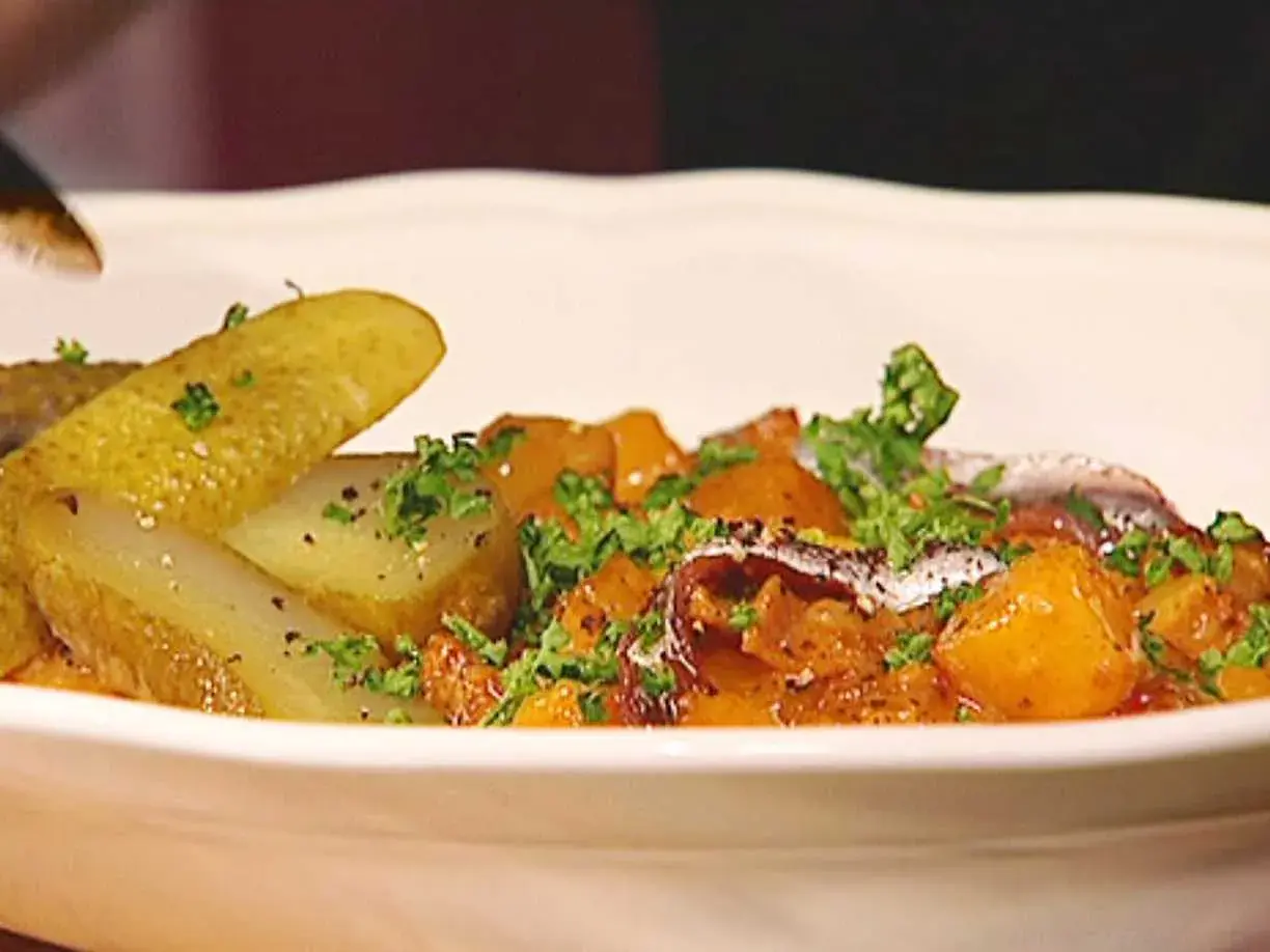 En portion pytt Bellman med stekt potatis, inlagd gurka och en ansjovisfilé.