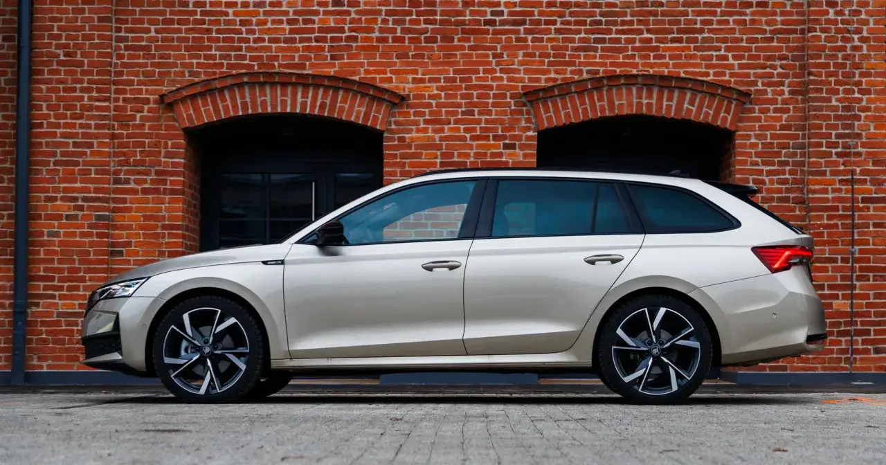 Złoty kombi Octavia 4 stoi na tle ceglanej ściany z dwoma łukowatymi oknami.