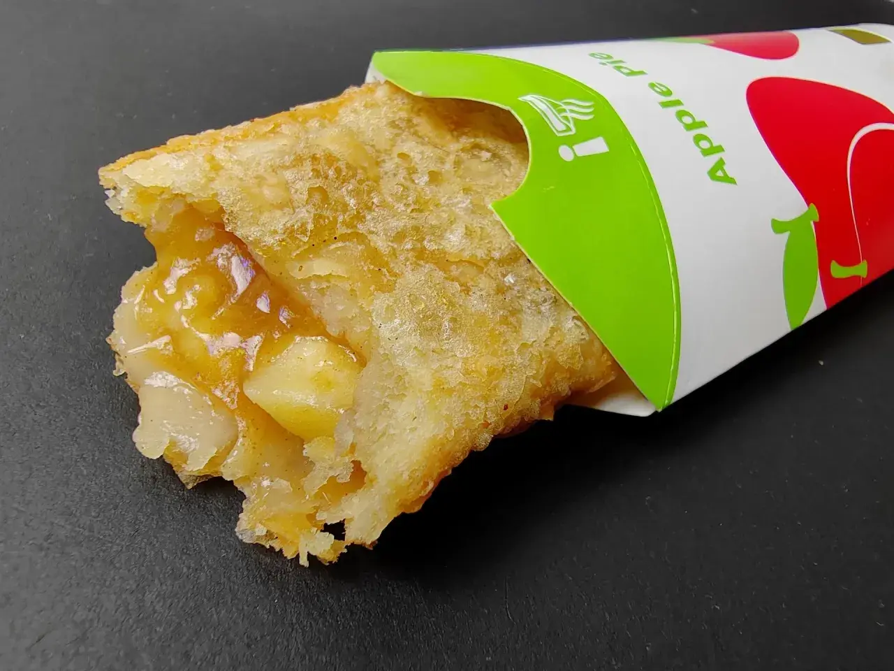 Chrupiące ciastko jabłkowe McDonald's z widocznym nadzieniem. Idealne na szybką przekąskę, choć warto sprawdzić jego kcal.