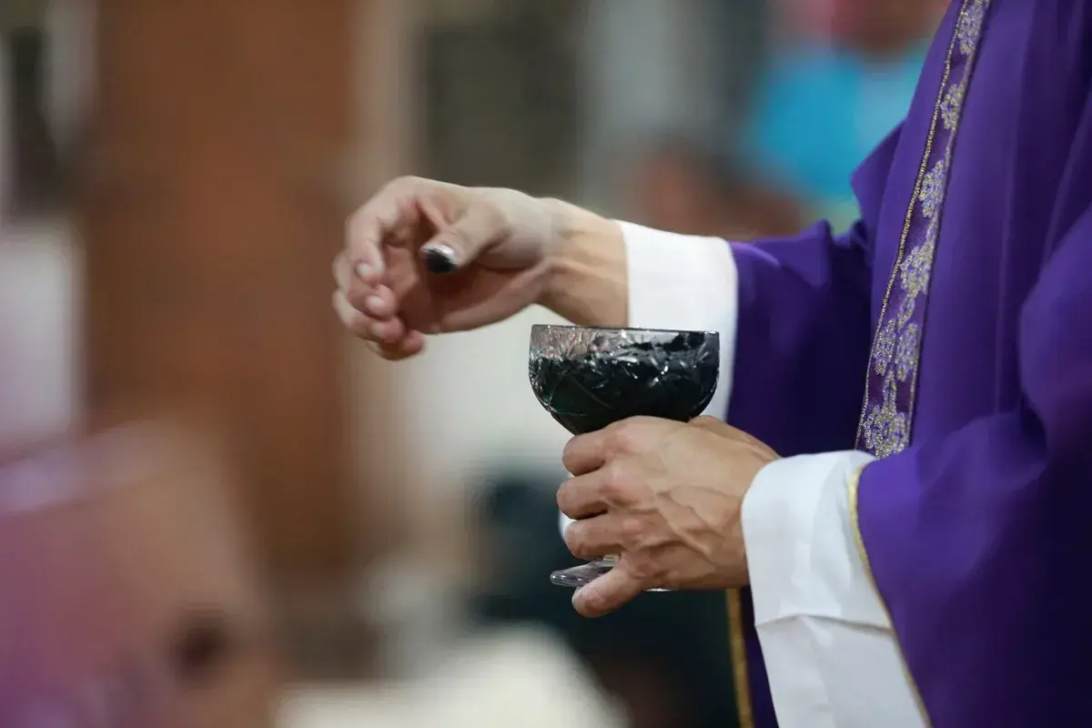 Dłoń księdza w purpurowej szacie trzyma kielich z winem. Dziś, 15 lutego, trwa ważna ceremonia.