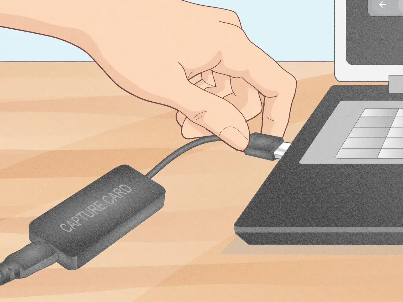 Dłoń podłącza kabel karty przechwytującej do laptopa.
