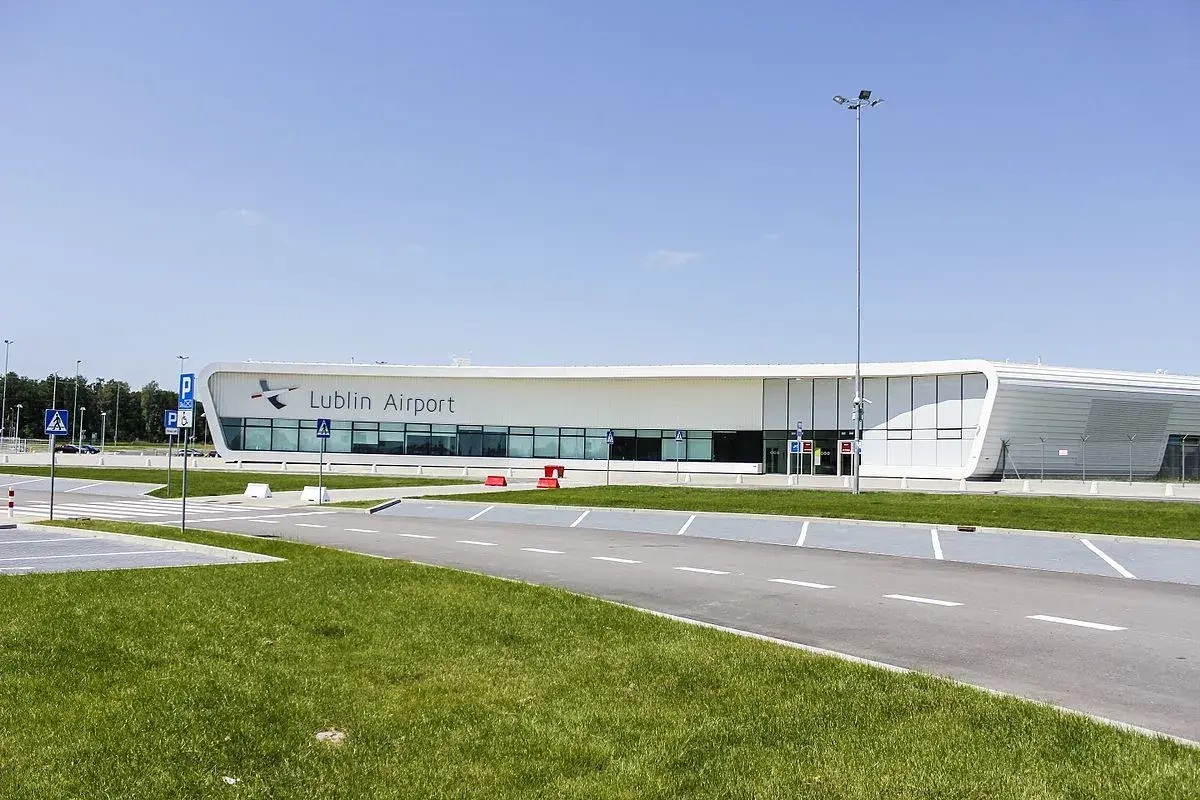 Nowoczesny budynek lotniska Lublin Airport w Świdniku. Widok na parking i drogę prowadzącą do terminala, gdzie oczekiwane są przyloty.