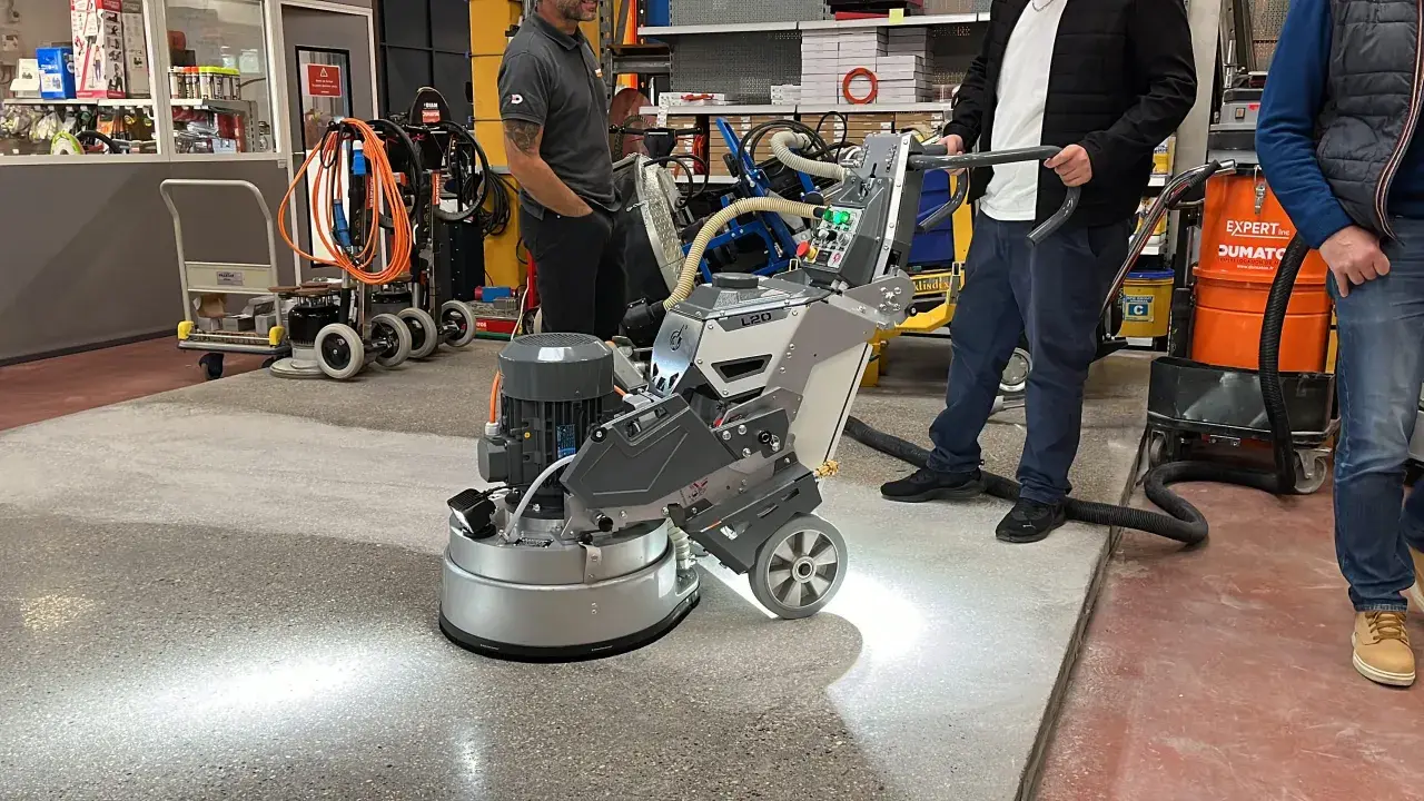 Une machine professionnelle est utilisée pour poncer du béton, créant une surface lisse et propre.