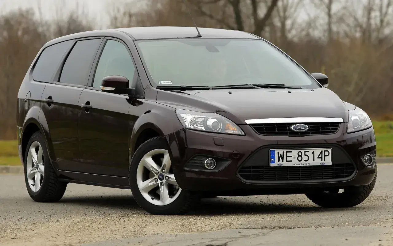 Ciemnobrązowy Ford Focus MK2 1.6 TDCI kombi stoi na szutrowej drodze.