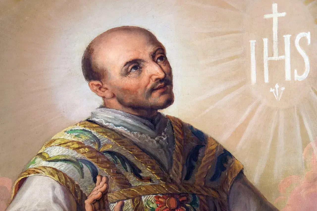 Święty Ignacy Loyola, którego wspomnienie przypada na 31 lipca, w chwale niebios. Widnieje symbol IHS.