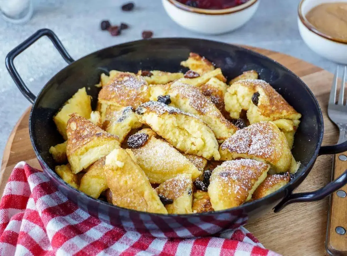Ein köstlicher Kaiserschmarrn, frisch aus der Pfanne, mit Rosinen und Puderzucker bestäubt. Ein einfaches Rezept für Genuss.