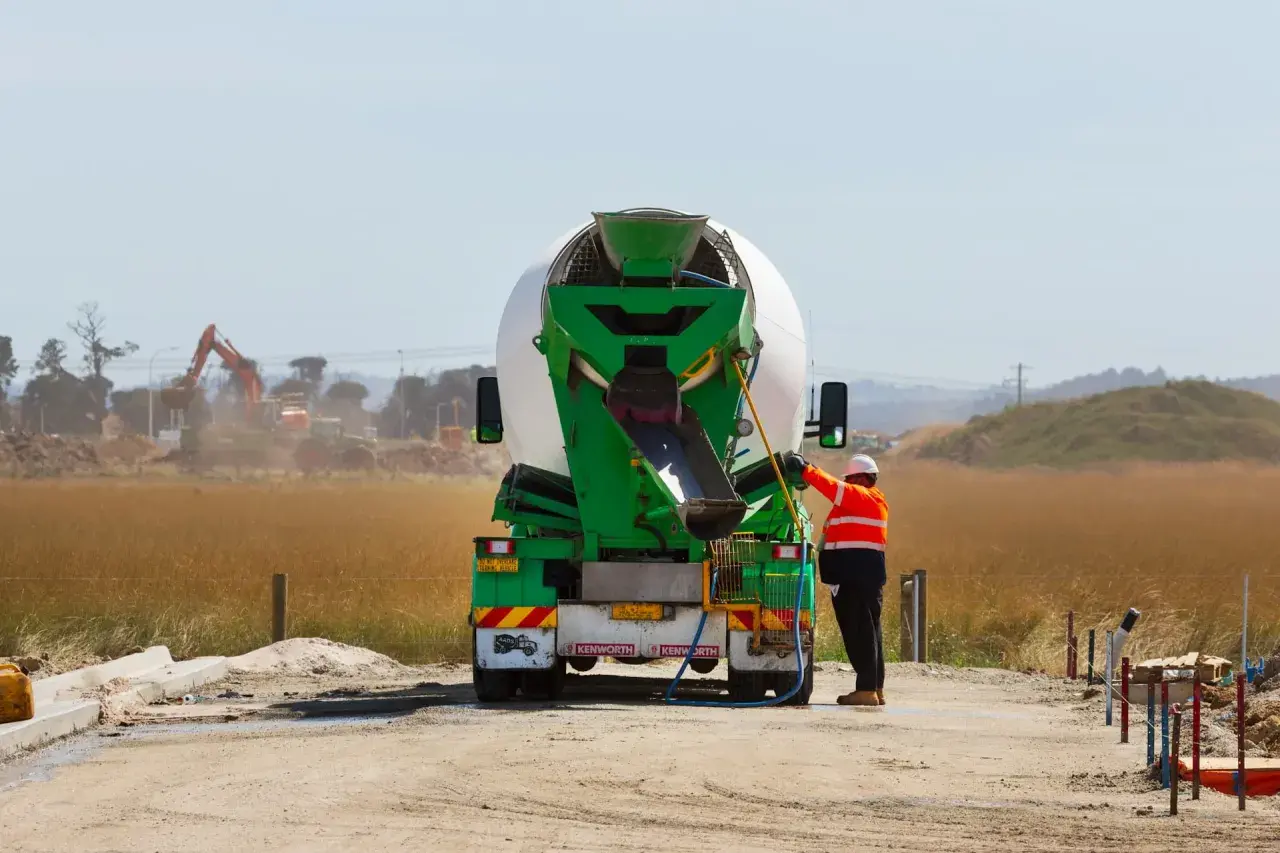 Robotnik przy betoniarce, przygotowuje się do pracy. Cena betonu zależy od wielu czynników.