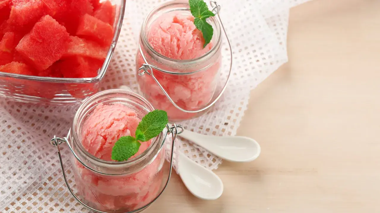 Erfrischendes Meloneneis selber machen: Fruchtige Wassermelonenstücke in Gläsern mit Minze garniert. Perfekt für heiße Tage!