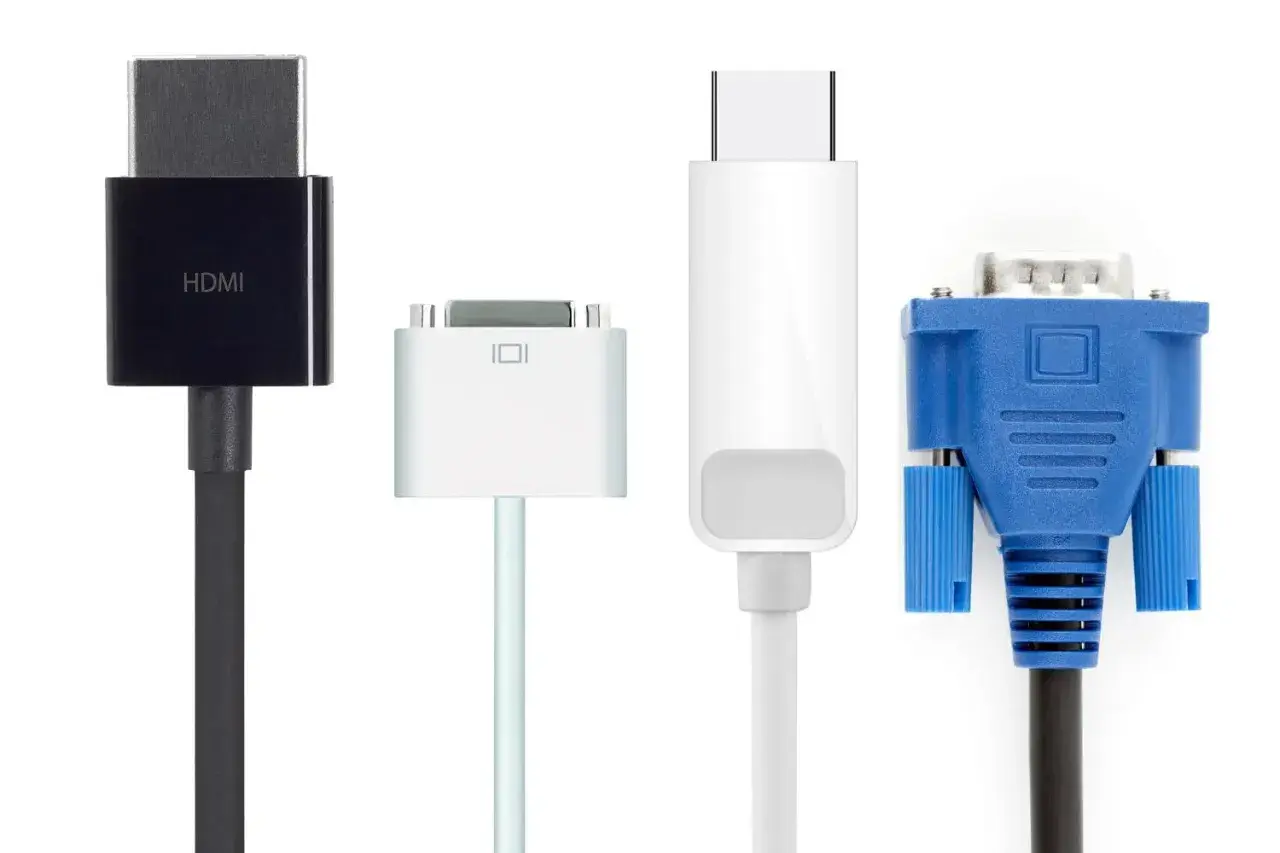 Czarny kabel HDMI, biały adapter, biały kabel USB-C i niebieski kabel VGA. Porównanie złącz: displayport vs hdmi i starsze standardy.