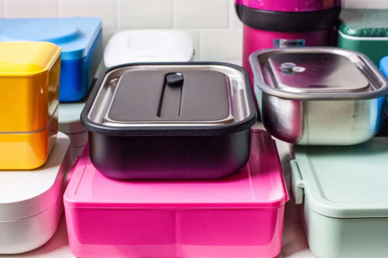 A colorful assortment of various types of bento boxes, including stainless steel, plastic, and stacked designs, ready for a delicious meal.