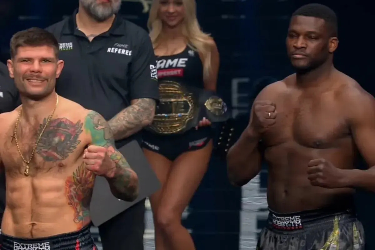 Dwóch zawodników MMA, jeden z tatuażami na klatce piersiowej, gotowych do walki. W tle ring girl z pasem mistrzowskim FAME. Wyniki walki będą emocjonujące!