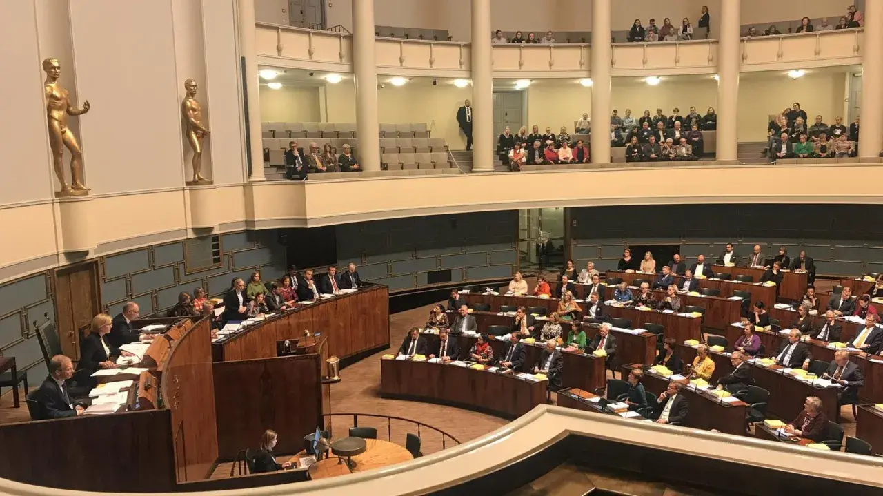 Im finnischen Parlament diskutieren Abgeordnete über wichtige Themen. Goldene Statuen schmücken die Wände des Plenarsaals.