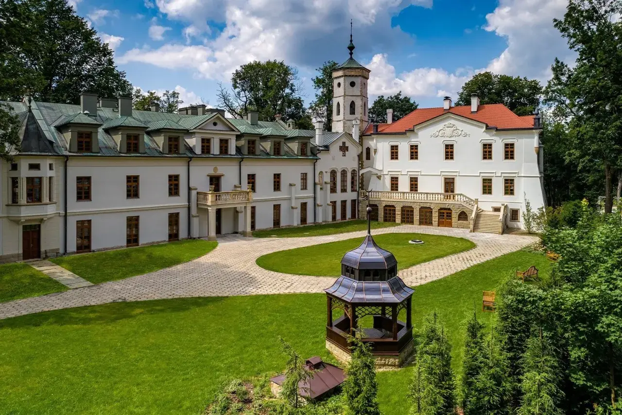 Pałac w Nawojowej z wieżą i altaną na dziedzińcu.