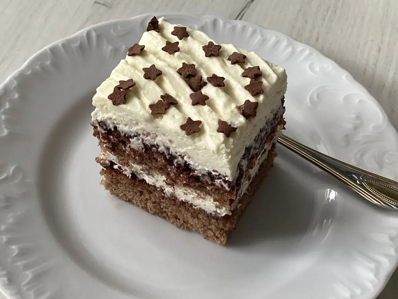 Pyszne ciasto z mascarpone, przełożone kremem i dżemem, ozdobione gwiazdkami. Idealne na deser.