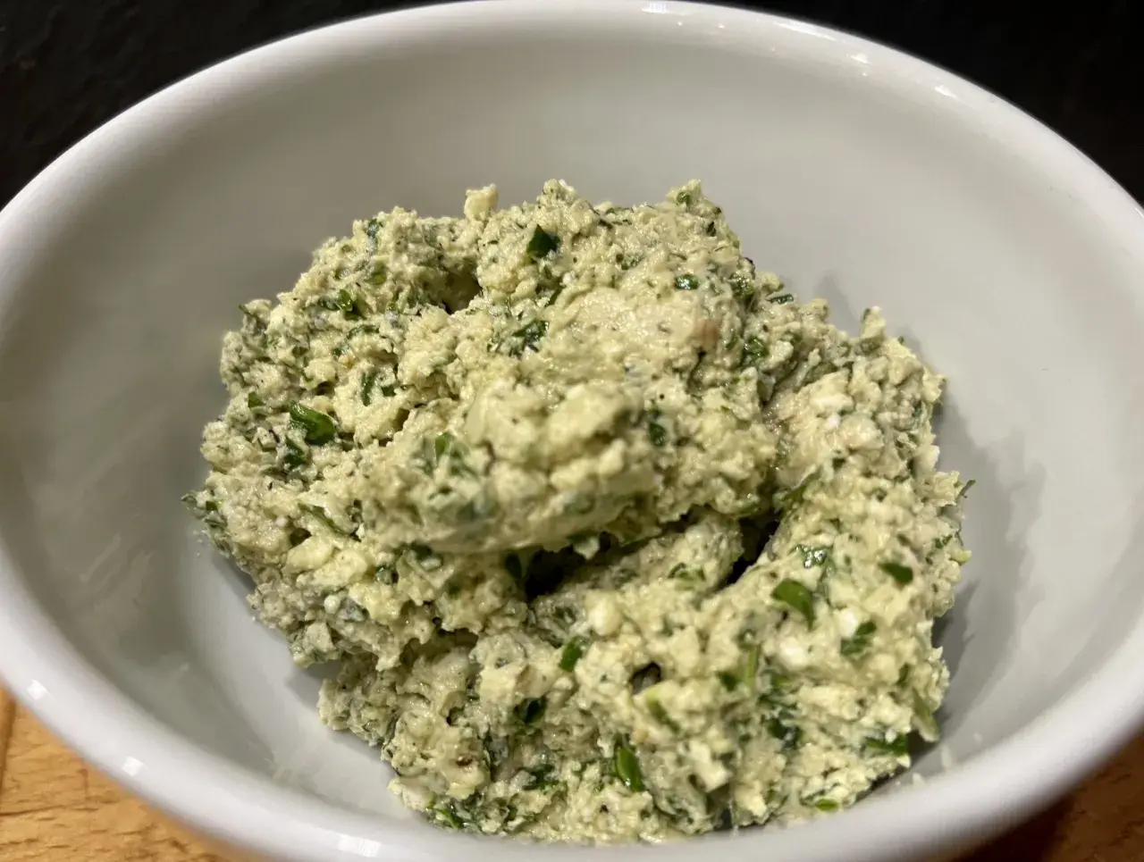 Frisch zubereitetes Moretum-Rezept in einer weißen Schüssel, ein cremiger Käseaufstrich mit Kräutern.