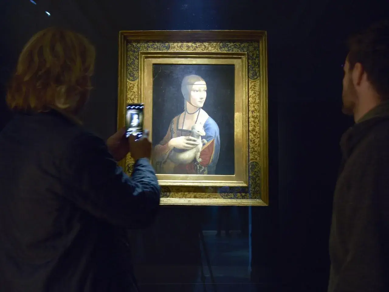 Dama z gronostajem w Muzeum Książąt Czartoryskich w Krakowie. Kobieta robi zdjęcie obrazu telefonem.