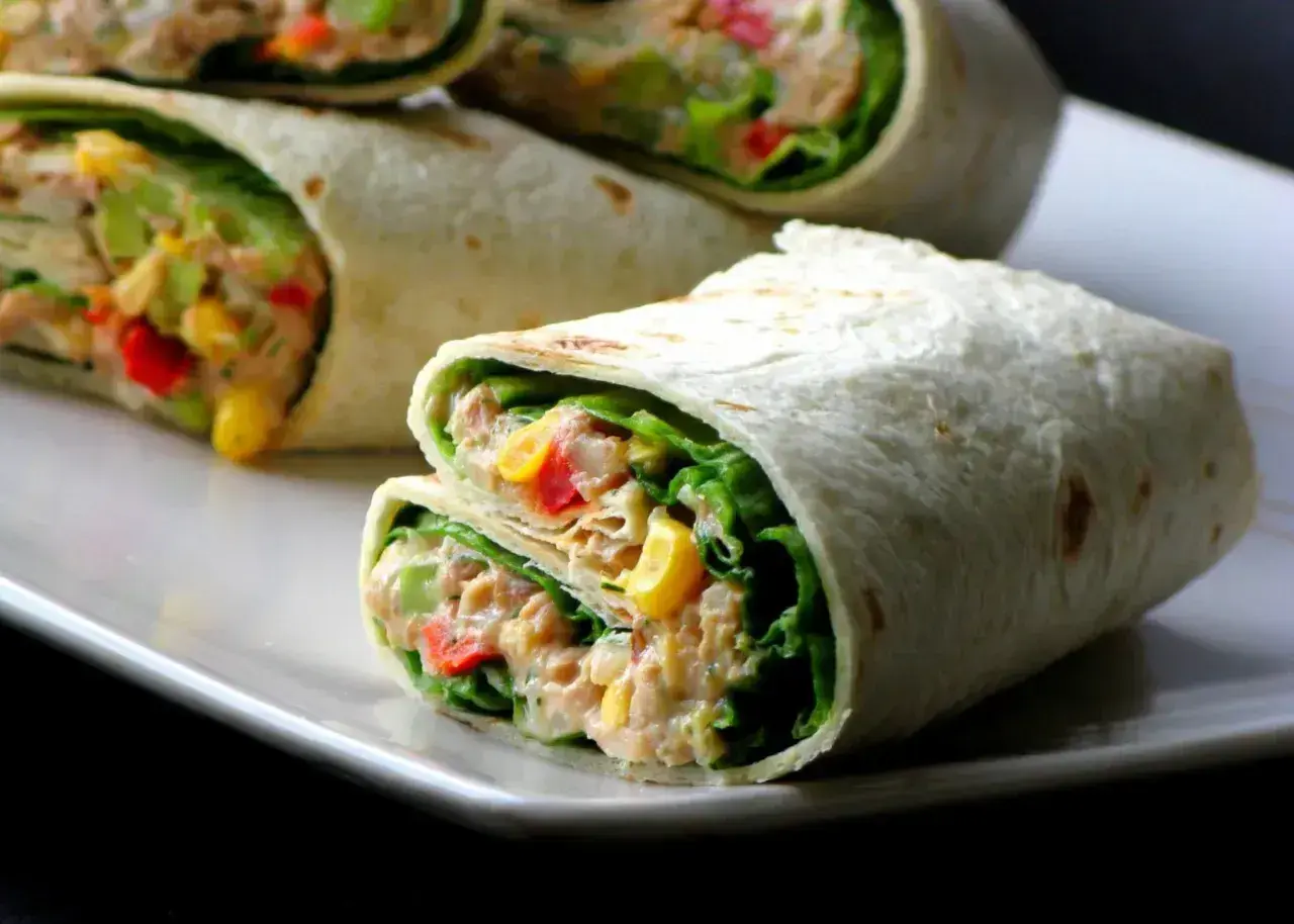 Pyszna tortilla z tuńczykiem, chrupiącą sałatą, kukurydzą i papryką. Idealna na szybki lunch.