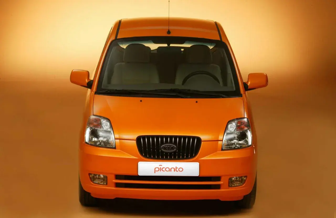 Vista frontale di una Kia Picanto arancione. Nonostante il suo aspetto allegro, alcuni proprietari segnalano **kia picanto difetti** comuni.