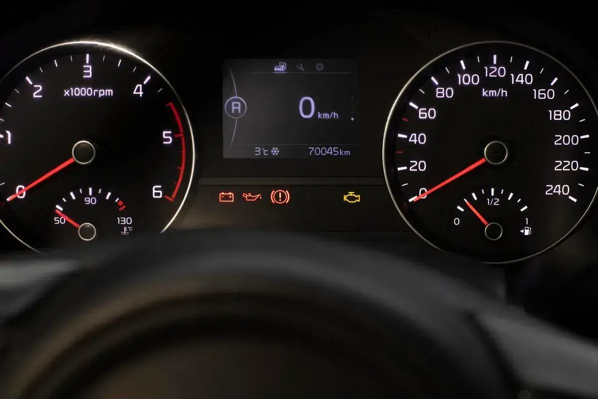 Tableau de bord d'une voiture avec indicateurs allumés, dont le voyant moteur. Le kilométrage est de 70045 km. Ce n'est pas une liste voyant Iveco.