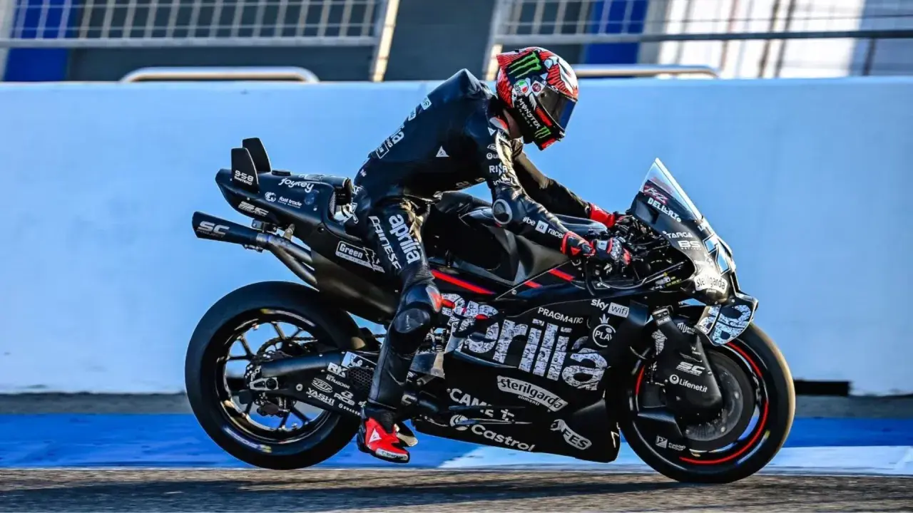 Marco Bezzecchi in voller Fahrt bei einem MotoGP-Rennen. Sein schwarzer Anzug und das Motorrad sind mit Sponsorenlogos bedeckt.