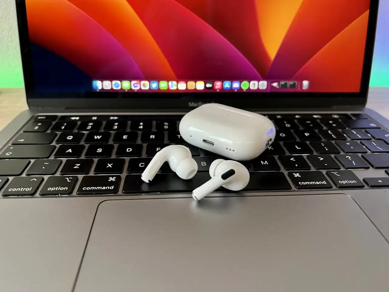 AirPods i etui na klawiaturze MacBooka. Dowiedz się, jak podłączyć AirPods do laptopa, aby cieszyć się bezprzewodowym dźwiękiem.
