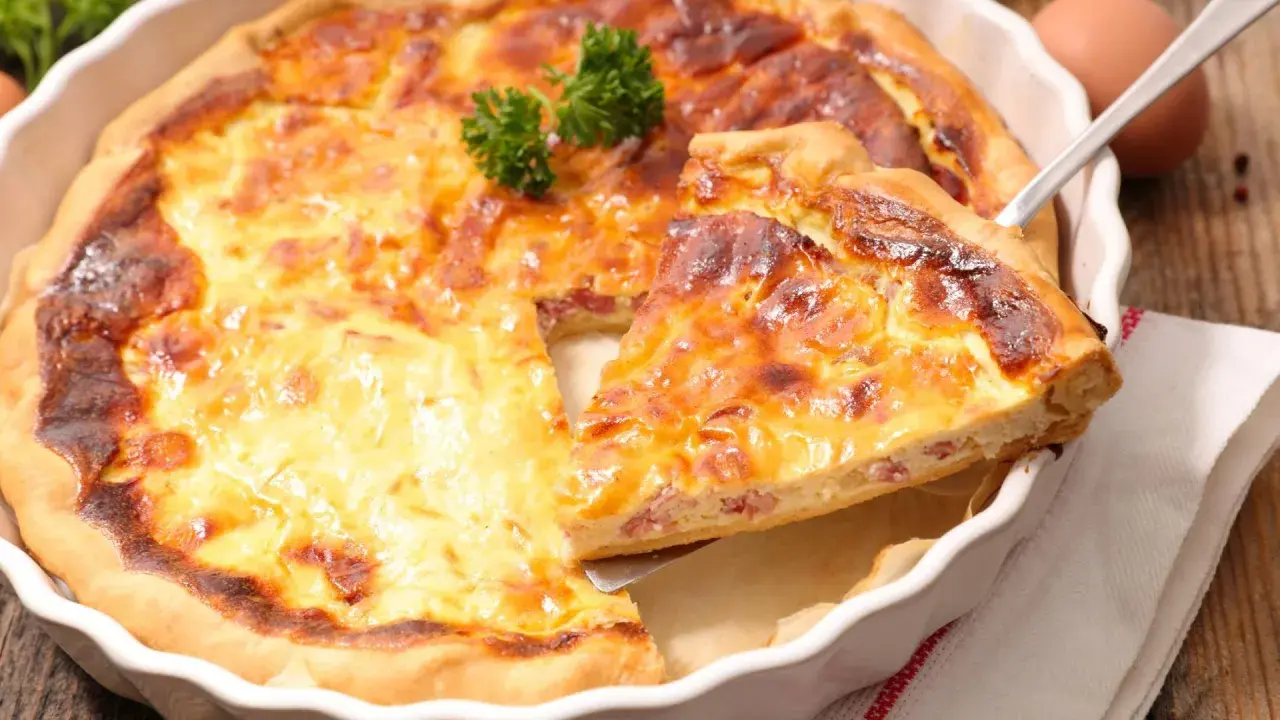 Une part de quiche lorraine dorée et appétissante, prête à être dégustée. La vraie recette quiche lorraine, un délice !