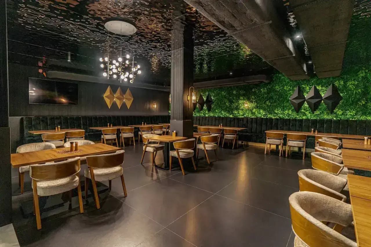 Elegancka restauracja z zieloną ścianą i nowoczesnym sufitem. Idealne miejsce na wykwintne białowieża jedzenie.