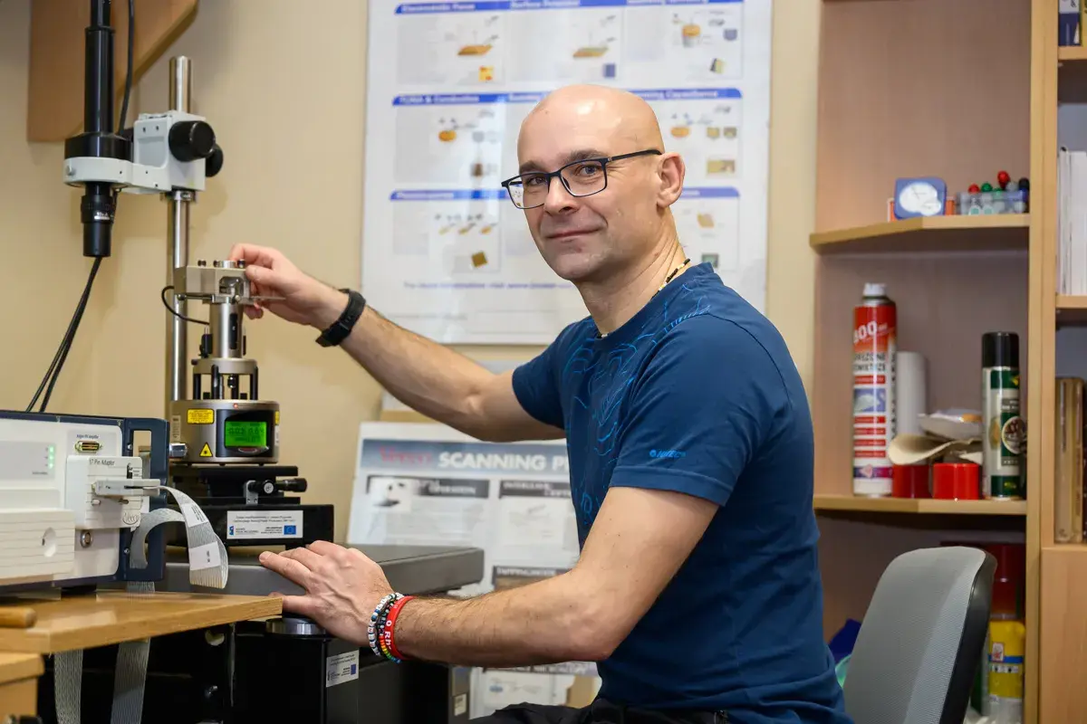 Naukowcowiec pracuje przy zaawansowanym sprzęcie, który umożliwia badania w skali nanotechnologii.