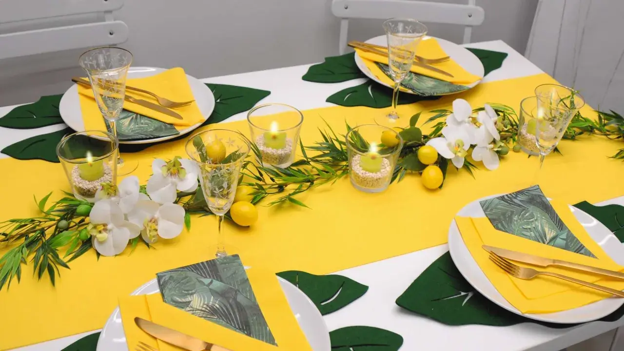 Eine sommerliche Tafel mit gelbem Läufer, Orchideen, Zitronen und Kerzen. Perfekt für schnelle Tischdeko Sommer.