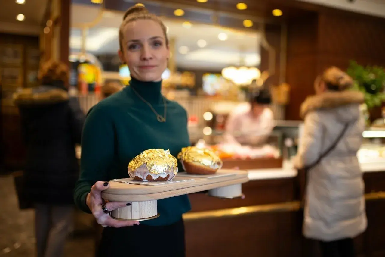 Elegancka piekarnia po francusku prezentuje dwa pączki w płatkach złota.