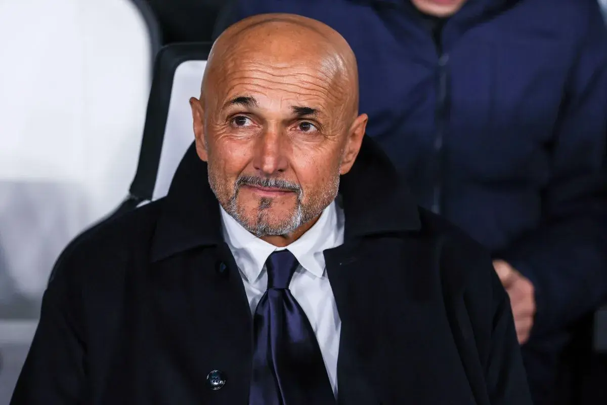 Łysy mężczyzna z brodą, ubrany w białą koszulę i granatowy krawat, w ciemnym płaszczu. To trener Juventusu, wpatrzony w dal.