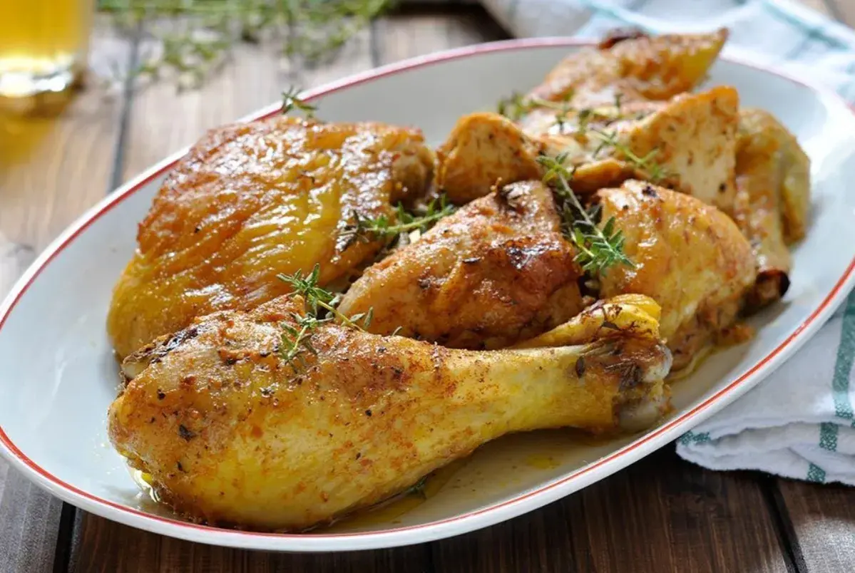Sovracosce di pollo al forno dorate e succulente, guarnite con rametti di timo fresco. Un piatto invitante pronto per essere gustato.