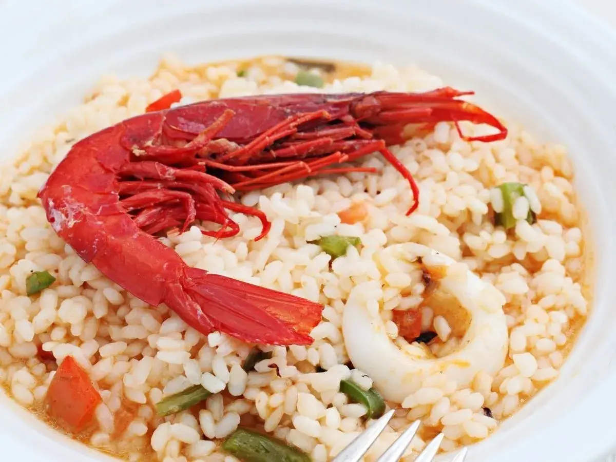 Delicioso arroz con carabineros, calamares y verduras. Un plato que huele a mar y sabe a tradición.