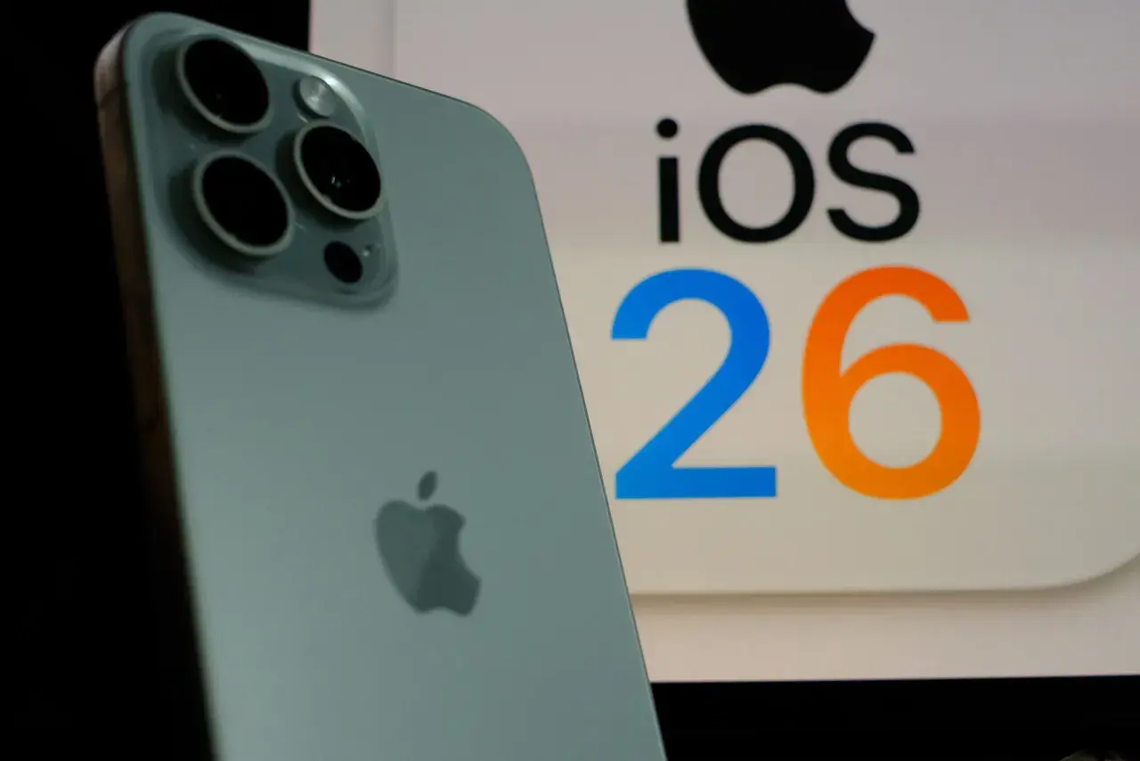 iPhone z systemem iOS 26.3, z widocznym logo Apple i aparatem.