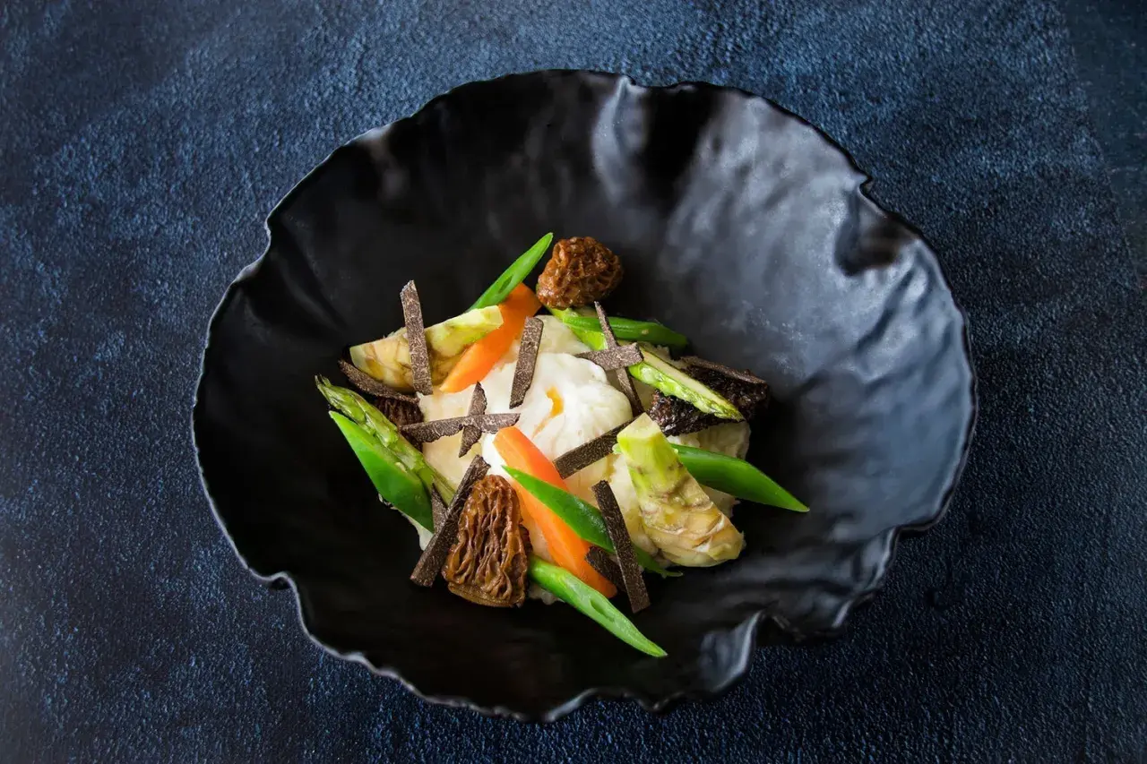 Parmentier de patata con espárragos, zanahorias, morillas y láminas de trufa negra.
