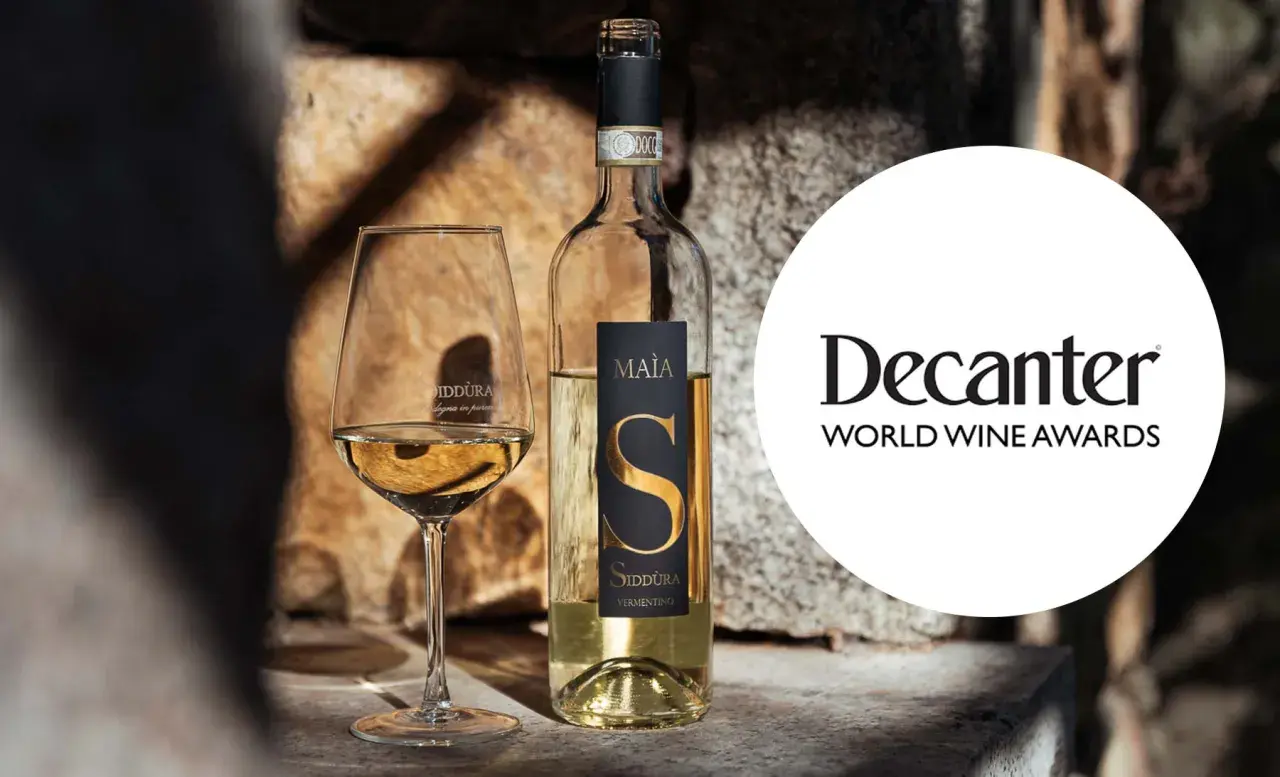 Calice e bottiglia di Vermentino Siddùra Maia, tra i migliori vini bianchi italiani premiati da Decanter World Wine Awards.