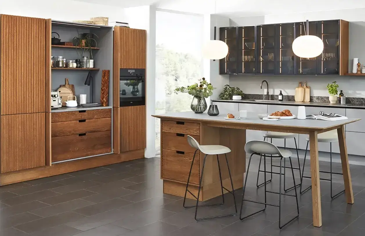 En modern köksö med barstolar, perfekt för en mysig kaffebar hemma. Trädetaljer och stilren design.