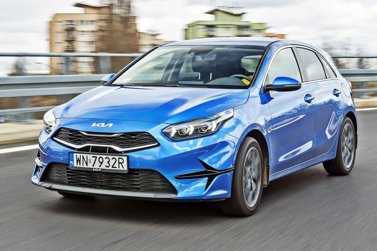 Niebieskie Kia Ceed w ruchu. Wiele pozytywnych kia ceed opinie potwierdza jego dynamiczny wygląd i komfort jazdy.
