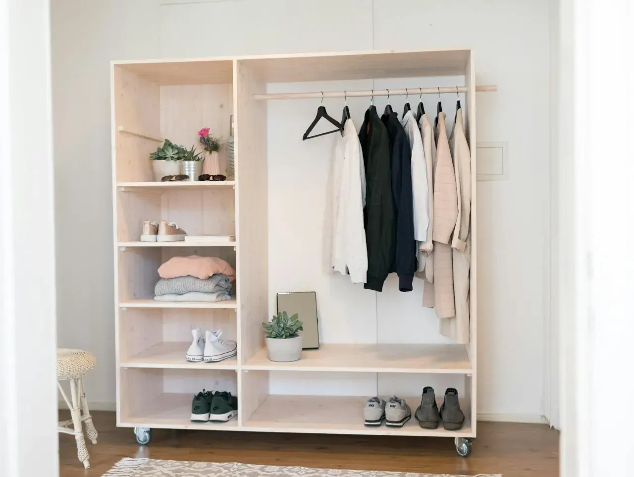 Ein offener Kleiderschrank selber bauen: Holzregal mit Kleiderstange, Schuhen und Deko.