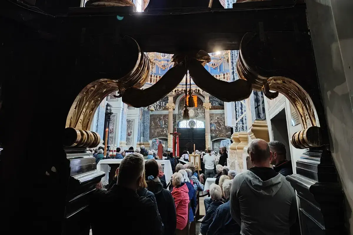 Wnętrze kościoła, tłum wiernych. Widać ołtarz i malowidła. Święta Lipka atrakcje przyciągają wielu pielgrzymów.