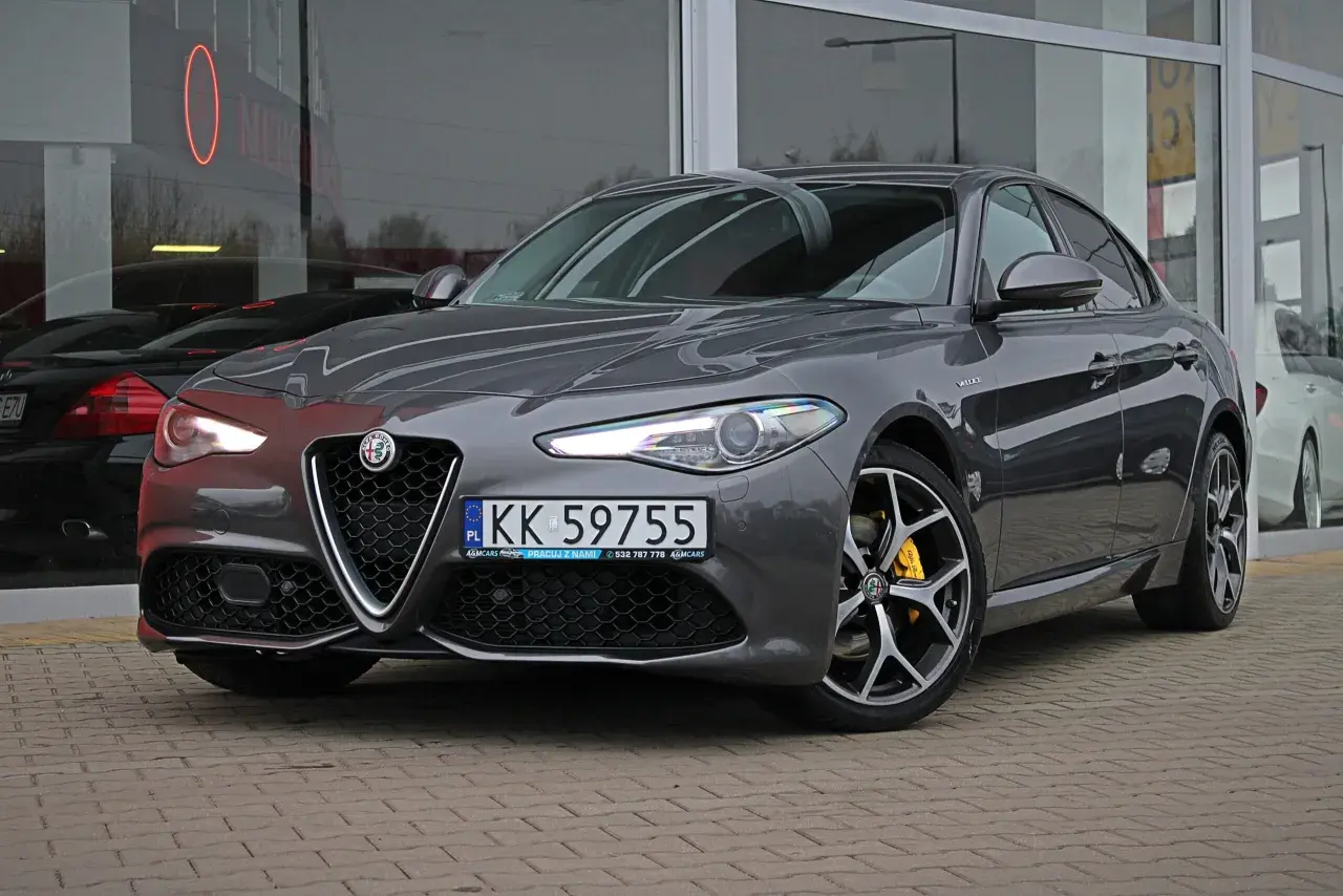 Szary Alfa Romeo Giulia Q4 z żółtymi zaciskami hamulcowymi i felgami z polerowanego aluminium.