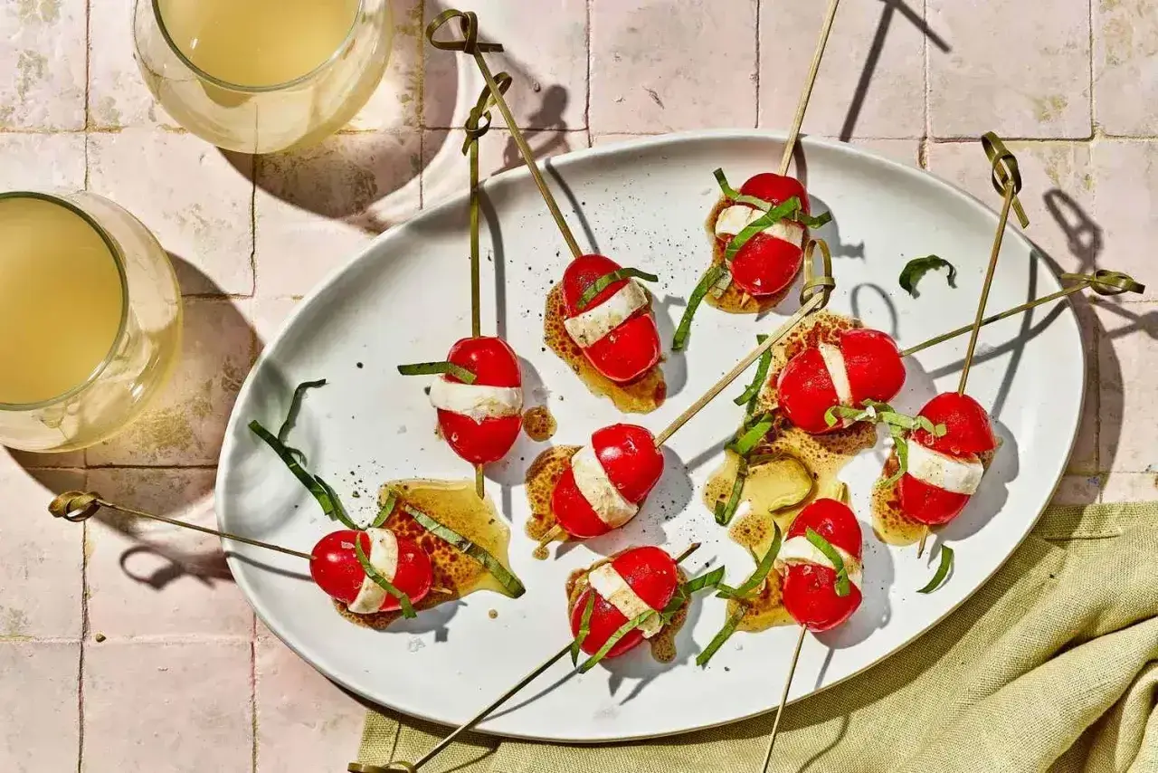 Proste przepisy na przekąski w 15 minut: szaszłyki caprese z pomidorków, mozzarelli i bazylii na chrupiącym grzanie.