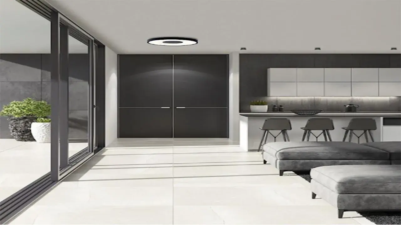 Luminaria circular de plafon 40 cm ilumina un salón moderno con puertas correderas, cocina y sofás grises.