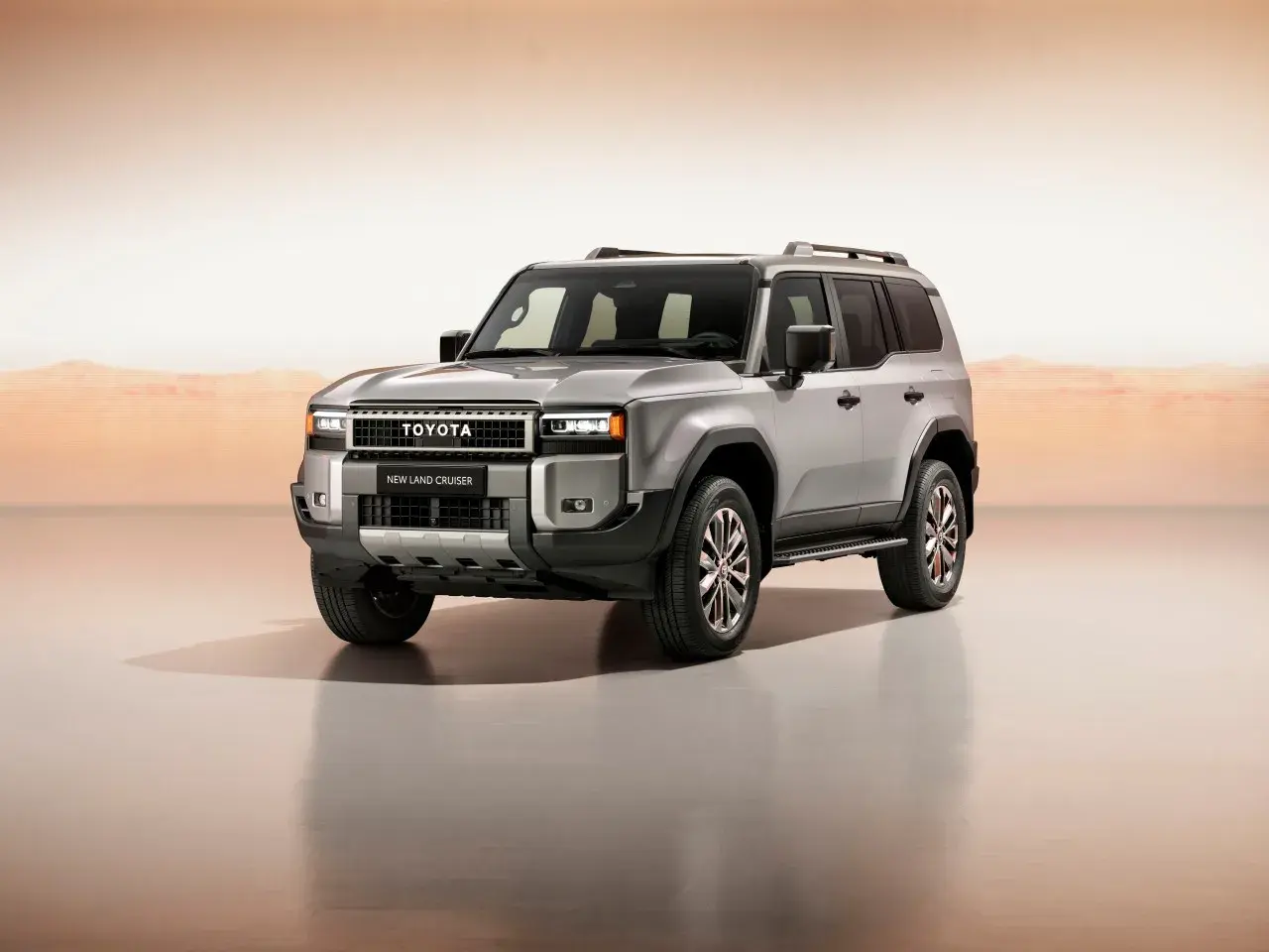 Srebrny, nowy Toyota Land Cruiser 2024 z masywnym grillem i nowoczesnymi światłami, gotowy na każdą przygodę.